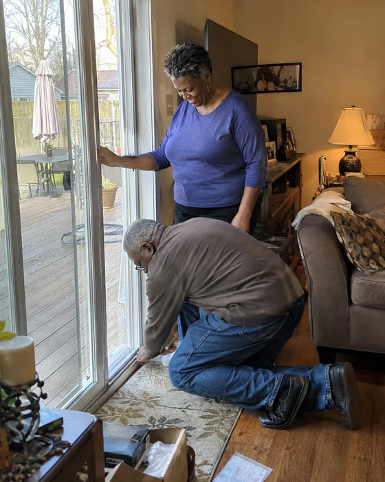 A couple working on the track of their sliding patio door