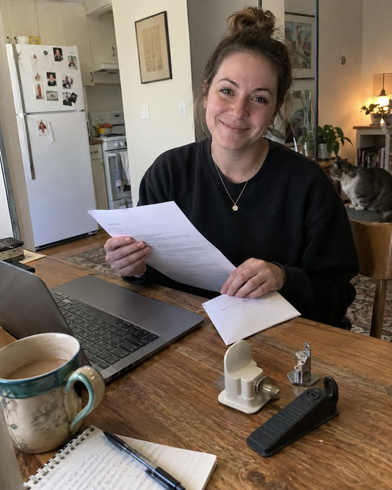 A reader at her kitchen table with the insurance letter template printed out