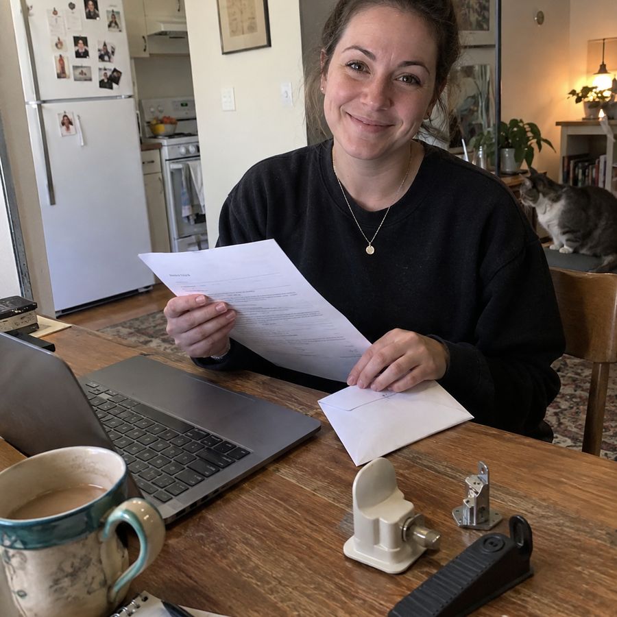 A woman at a kitchen table filling in the insurance letter